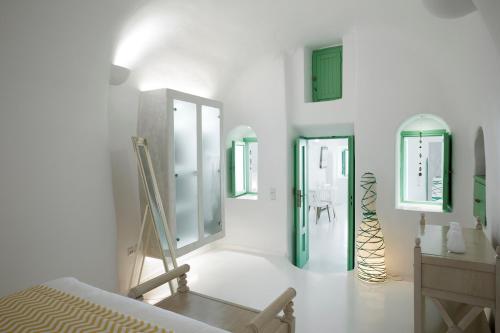 a room with white walls and green doors and a staircase at Dreams Luxury Suites in Imerovigli