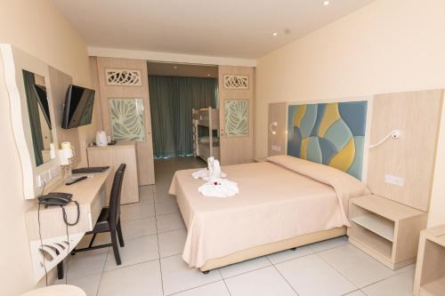 a hotel room with a bed and a desk at Tofinis Hotel in Ayia Napa