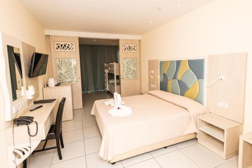 a hotel room with a bed and a desk at Tofinis Hotel in Ayia Napa