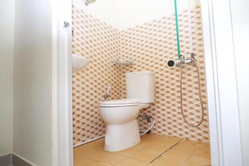 a bathroom with a toilet and a shower at Ayuning Guest House Syariah Semarang Mitra RedDoorz in Semarang
