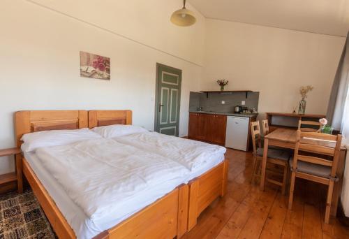 a bedroom with a bed and a table and a kitchen at Penzion Dvůr Krasíkov in Kokašice