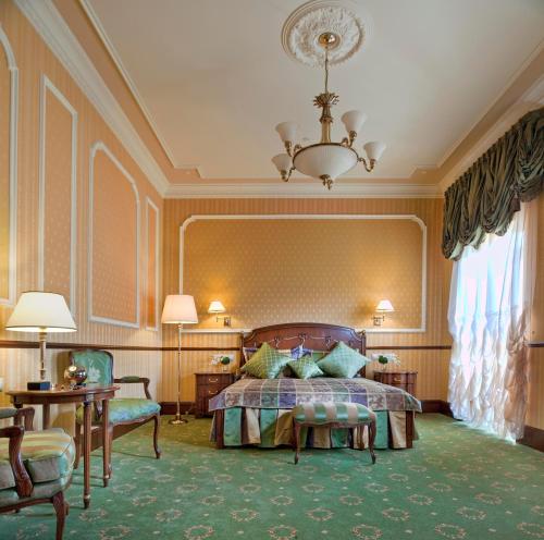 um quarto grande com uma cama e um lustre em Hotel Bristol em Odessa