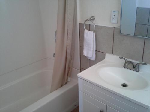 een witte badkamer met een wastafel en een bad bij Boron Motel in Boron