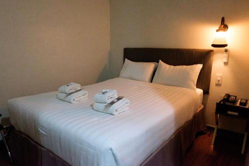 a bedroom with a bed with two towels on it at CREVICE HOTEL in Davao City