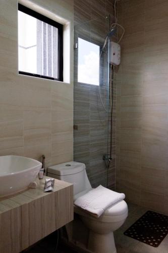 a bathroom with a toilet and a sink and a shower at CREVICE HOTEL in Davao City