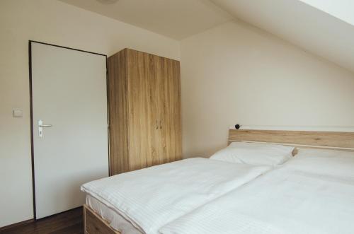 a bedroom with a bed and a wooden cabinet at Guest House Na Hřišti in Leština