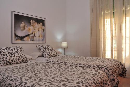 1 dormitorio con 1 cama y una foto en la pared en Apartamentos Bejar en Barcelona