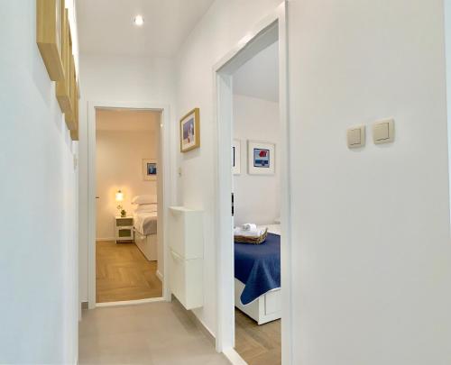 - un couloir avec une chambre dotée d'un lit et d'un miroir dans l'établissement 17 Pines, à Makarska
