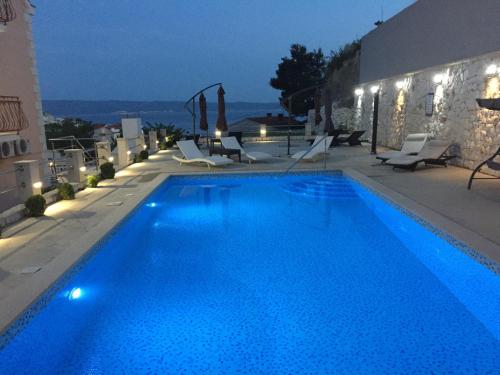 a large blue swimming pool on top of a building at Bed & Breakfast Senator in Podstrana