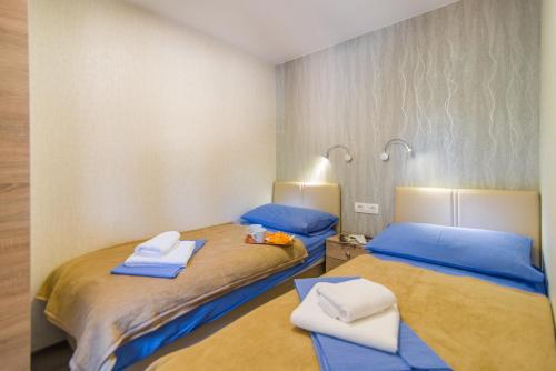 two beds in a room with blue sheets and towels at Centinera Deluxe Mobile Homes in Banjole