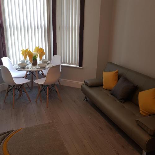 a living room with a couch and a table with yellow pillows at Hollis House - 5 Bedroom Contractor Accommodation in Derby in Derby