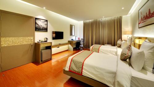 a hotel room with two beds and a television at Ramada by Wyndham Bengaluru Yelahanka in Yelahanka
