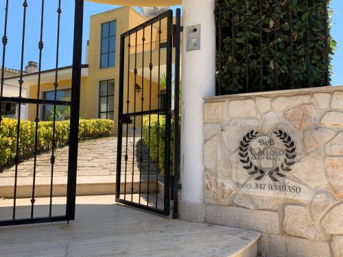 a gate to a building with a sign on it at BeB L'ALLORO in Pachino