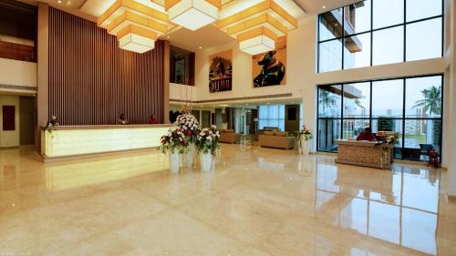 a lobby with flowers in vases on the floor at Ramada by Wyndham Bengaluru Yelahanka in Yelahanka
