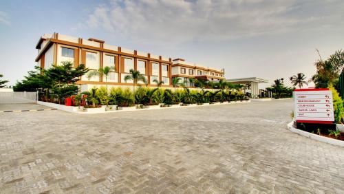 a building with palm trees in front of it at Ramada by Wyndham Bengaluru Yelahanka in Yelahanka