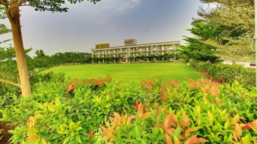 a building with a field of flowers in front of it at Ramada by Wyndham Bengaluru Yelahanka in Yelahanka