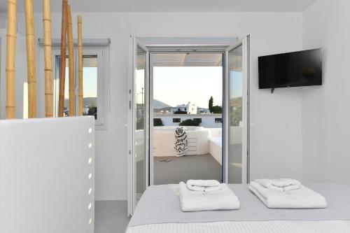 una camera da letto con un letto e due asciugamani di 21 luxury apartments a Naoussa