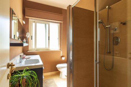 e bagno con servizi igienici, lavandino e doccia. di Domus Sicily - Villa Conca d'Oro with Pool a Palermo