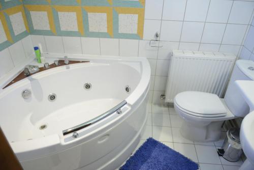 a bathroom with a white tub and a toilet at Crambero Suites in Alona