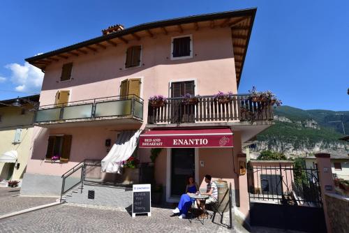 deux personnes assises à une table à l'extérieur d'un bâtiment dans l'établissement B&B ENANTIO, à Belluno Veronese