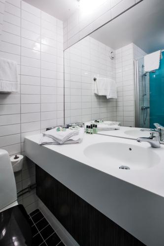 a white bathroom with a sink and a mirror at Elite City Hotel, Örebro in Örebro