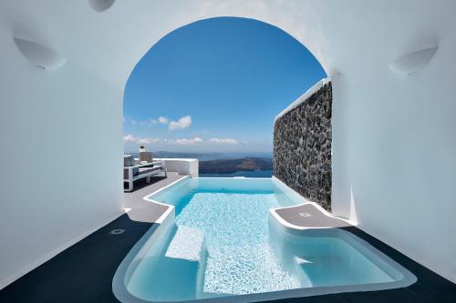 a swimming pool in the middle of a white house at Dreams Luxury Suites in Imerovigli
