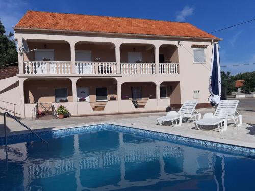 una casa con piscina di fronte a una casa di Apartment Elena a Galovac