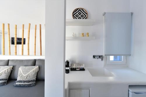 a white kitchen with a couch and baseball bats at 21 luxury apartments in Naousa