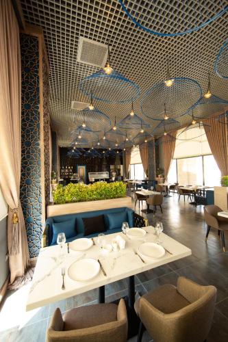 a dining room with a table with sinks and chairs at Saat Meydani Nakhchivan in Naxçıvan