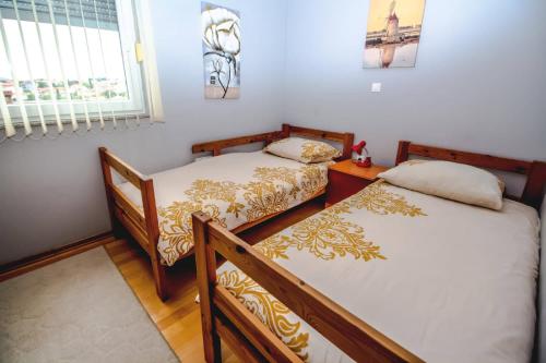 two twin beds in a room with a window at Apartments Saric in Pula