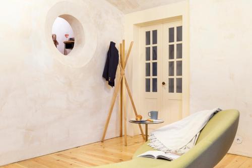 a living room with a green chair and a mirror at Archi-Pelago Alfama Design Suites Guesthouse in Lisbon