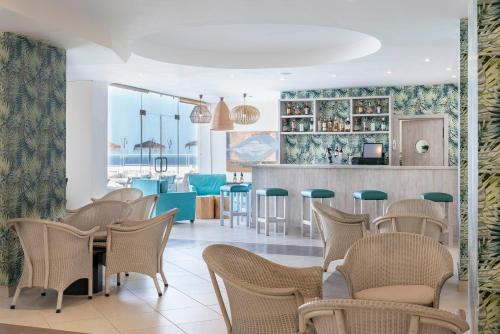 un restaurante con sillas, una mesa y un bar en Hotel Tenerife Golf & Seaview en San Miguel de Abona