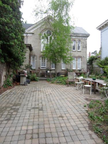 a patio in front of a house with a table and chairs at Church Des Artistes in Kingston