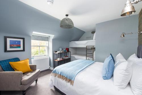 um quarto azul com uma cama e uma cadeira em The Kilchrenan Inn em Oban