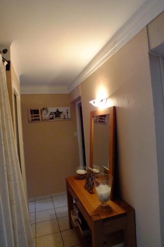 Cette chambre dispose d'un miroir et d'une table en bois avec un sidx de table. dans l'établissement F3 avec parking le dauphin, à Sète