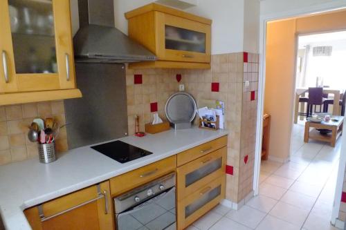 une cuisine avec des armoires en bois et un four à plaques de cuisson dans l'établissement F3 avec parking le dauphin, à Sète