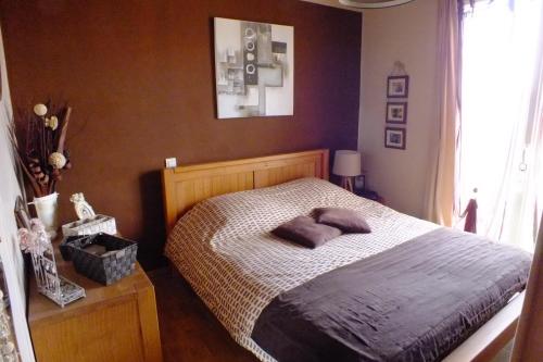 une chambre avec un lit avec deux oreillers dessus dans l'établissement F3 avec parking le dauphin, à Sète