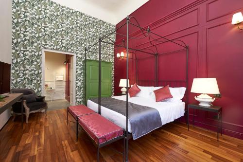 1 dormitorio con cama y pared roja en Peruzzi Urban Residences, en Florencia