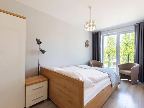 a bedroom with a bed and a large window at VacationClub - Pionierów 6, Apartament 25 in Mielno