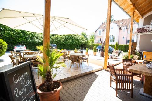 a patio with tables and chairs and an umbrella at Vila Belaggio in Plattling