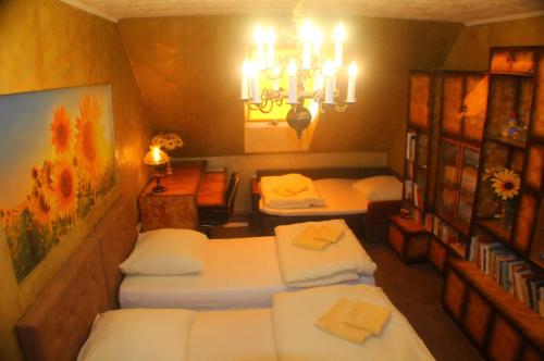 a room with three beds and a chandelier at Arkady in Słupsk