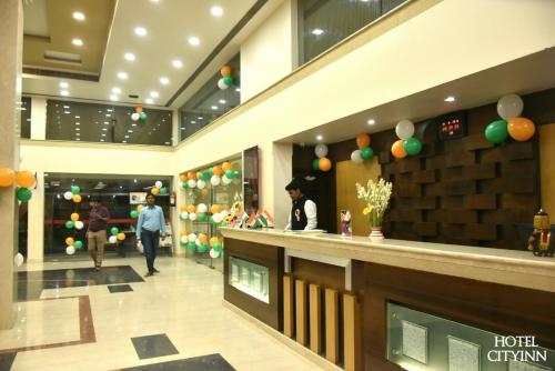 a lobby with people walking in a mall with balloons at Hotel City Inn in Varanasi