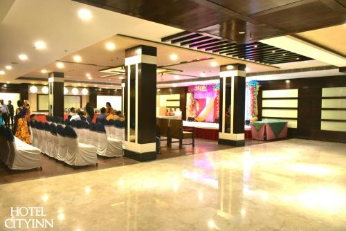 a hotel lobby with people sitting in chairs and a bar at Hotel City Inn in Varanasi