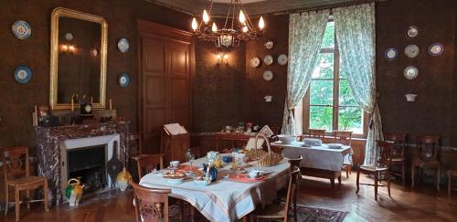 a dining room with a table and chairs and a fireplace at Château des Martinanches in Saint-Dier-dʼAuvergne