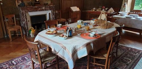 een eettafel met een wit tafelkleed bij Château des Martinanches in Saint-Dier-dʼAuvergne