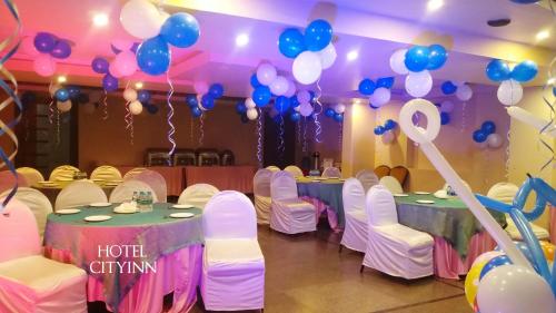 a room with two tables with blue and white balloons at Hotel City Inn in Varanasi