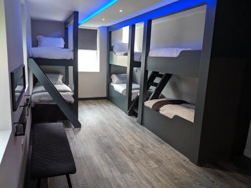 een kamer met 3 stapelbedden en een blauw licht bij Vibe Holiday Apartments in Blackpool