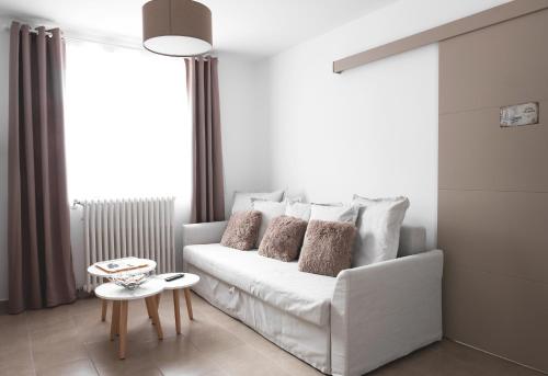 a living room with a white couch and a table at Au chalet des quatre saisons in Ax-les-Thermes