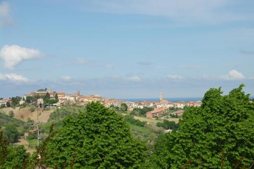 a group of trees with a town in the background at Camping Village Mar y Sierra in San Costanzo