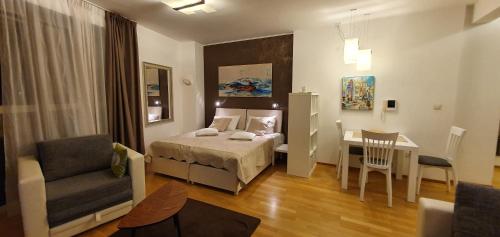 1 dormitorio con cama, escritorio y silla en Boutique Apartments, en Budva
